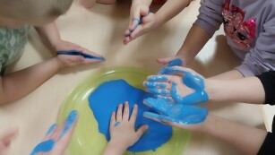Dzieci na znak solidarności malują ręce na niebiesko
